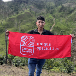 Producer Anthony Vasquez holding a flag on his coffee farm